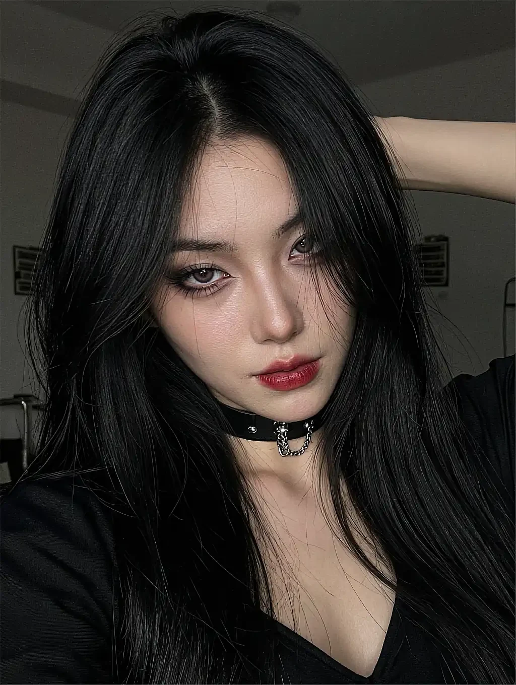 Fictional AI character with straight black hair and a choker in a white room
